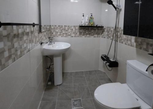 a white bathroom with a sink and a toilet at Haneul Cheon Ddaji Hanok in Yangyang