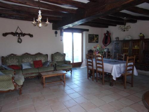 un salon avec un canapé, une table et des chaises dans l'établissement Ravissante Fermette Rénovée avec Jardin Clos, Cheminée et WiFi - Animaux Acceptés - FR-1-489-83, à Verneix