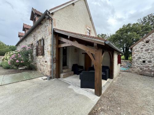 a building with an awning on the side of it at Maison de ferme restaurée avec mini ferme, terrasse et grand jardin près de la Vallée du Cher - FR-1-489-270 in Le Cluzeau