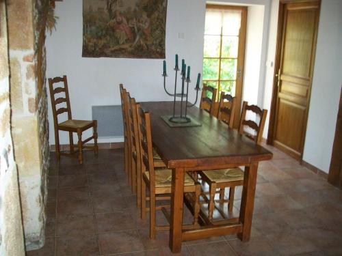 a dining room with a wooden table and chairs at Maison de ferme restaurée avec mini ferme, terrasse et grand jardin près de la Vallée du Cher - FR-1-489-270 in Le Cluzeau