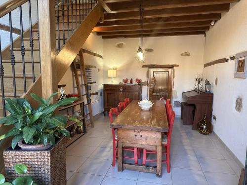 une salle à manger avec une table en bois et des chaises rouges dans l'établissement Grange rénovée avec jardin arboré, idéale pour séjours en famille ou entre amis, à Deneuille-les-Mines - FR-1-489-408, à Deneuille-les-Mines