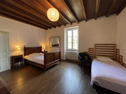 a bedroom with two beds and a window at Grande Ferme avec Piscine Privative et Jardin, Proche Étang, Chappes - FR-1-489-90 in Chappes