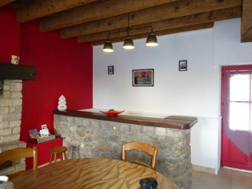 a dining room with a table and a red wall at Maison de vacances rénovée avec jardin, idéale famille, proche RCEA, équipée confort et tout inclus - FR-1-489-44 in Cressanges