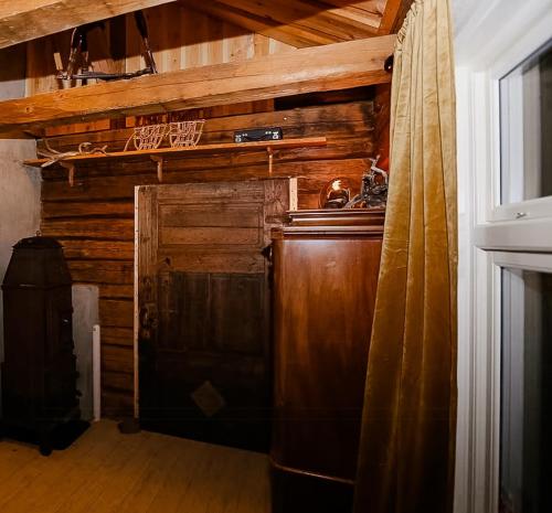 a kitchen with a refrigerator and a wooden wall at Historic Cabin By The Ski Trail In Østmarka in Omberg
