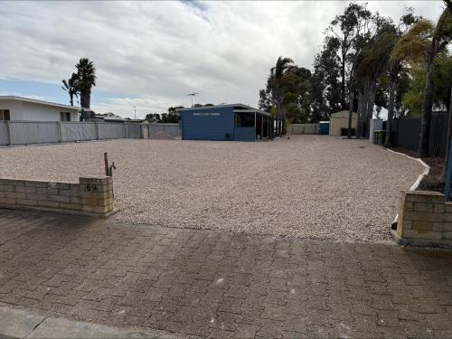 a large gravel parking lot with a blue building at 3 by the Sea at Coobowie Unit 2 in Coobowie