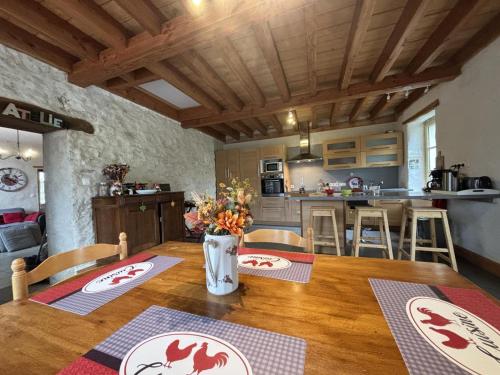 a kitchen and dining room with a wooden table and chairs at Charmante maison rénovée, 4-5 pers., jardin clos, près de Charroux et Ebreuil. Draps inclus, animaux OK - FR-1-489-181 in Saint-Bonnet-de-Rochefort