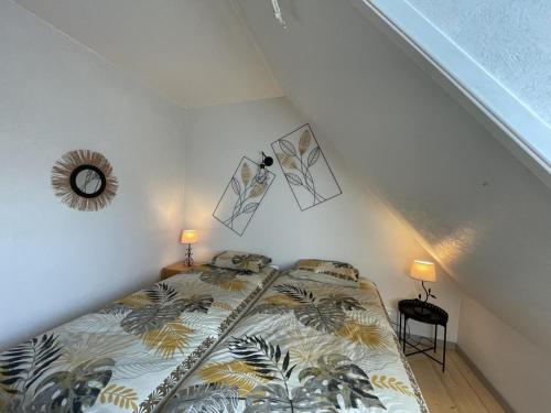 a bedroom with a bed in a attic with two lamps at Refuge familial avec piscine, aire de jeux et confort moderne à Blomard - FR-1-489-465 in Blomard
