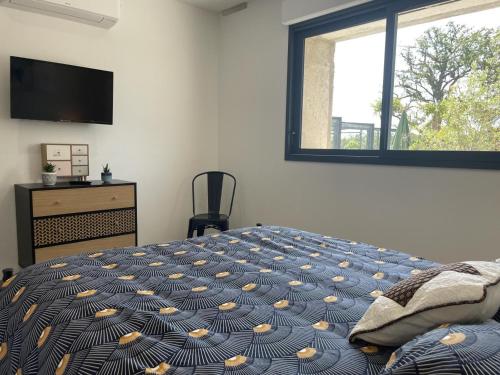 a bedroom with a bed and a tv and a window at Gîte rénové avec piscine chauffée couverte, climatisation, proche randonnées et attractions locales - FR-1-489-471 in Couzon
