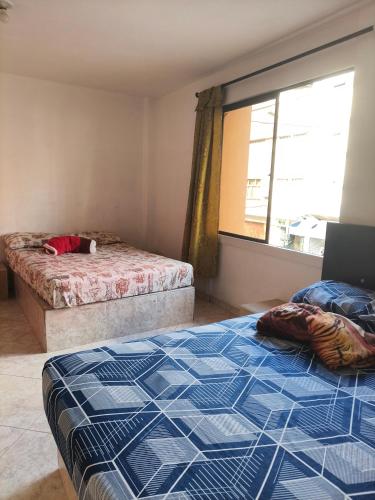 a bedroom with two beds and a window at Hotel San José Medellín in Medellín