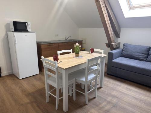 une cuisine avec une table avec des chaises et un réfrigérateur dans l'établissement Gîte rural avec animaux, parking et Wifi à Saint Bonnet de Four - FR-1-489-560, à Saint-Bonnet-de-Four