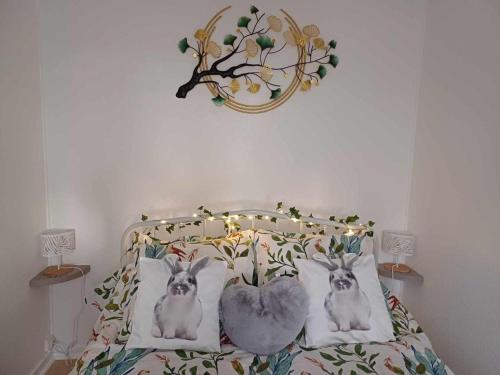 a bedroom with a bed with two rabbits on it at Chalet paisible avec jardin et wifi à Jenzat - FR-1-489-564 in Jenzat