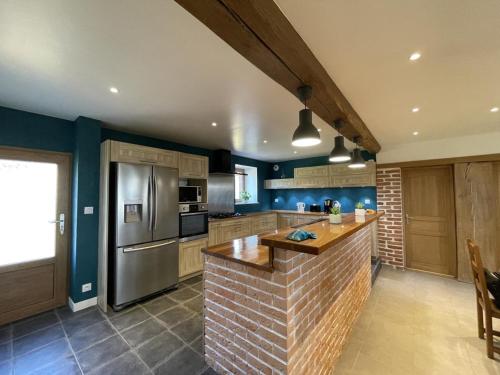 une cuisine avec un îlot en briques au milieu dans l'établissement Gîte nature à St Léon avec jardin et WIFI - FR-1-489-440, à Saint-Léon
