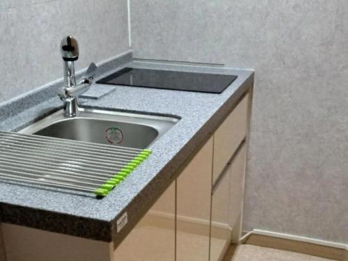 a kitchen sink with a green ruler next to it at Haneul Cheon Ddaji Hanok in Yangyang