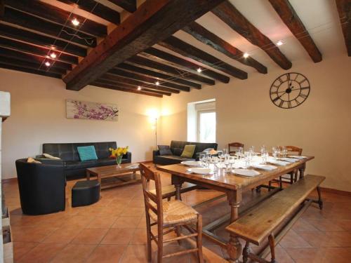 une salle à manger avec une table et un canapé dans l'établissement Maison de campagne rénovée avec jardin clos, terrasse, jeux, 5 chambres, et animaux acceptés - FR-1-497-109, à Mauves-sur-Huisne