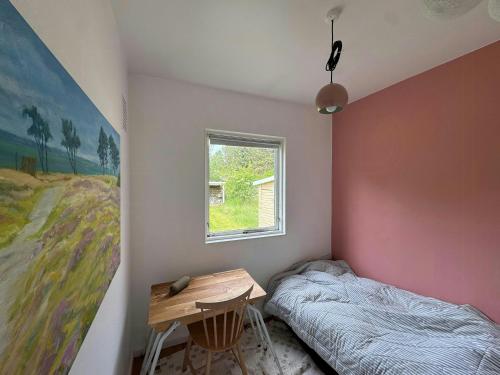 a bedroom with a desk and a bed and a window at Modern Holiday Home Close To Odden Beach in Tjørneholm