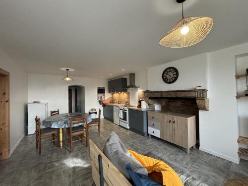 une cuisine et un salon avec une table et un canapé dans l'établissement Gîte champêtre à Saint-Léon : nature, randonnée, pêche, confort tout équipé, proche du PAL. - FR-1-489-518, à Saint-Léon