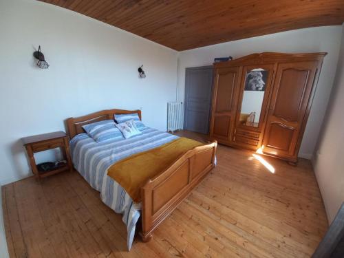 ein Schlafzimmer mit einem Bett und einem Holzboden in der Unterkunft Gîte paisible à Saint-Léon, proche nature et randonnées - FR-1-489-518 in Saint-Léon