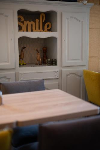 a dining room with a table and a smile sign at Hôtel La Couleuvrine Sarlat Centre Ville in Sarlat-la-Canéda
