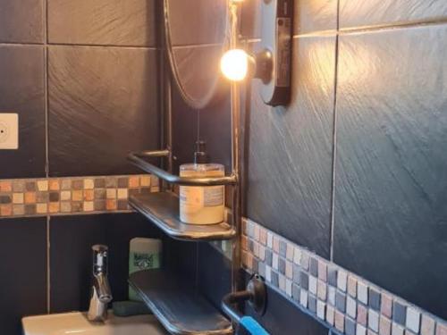 a bathroom with a sink and a light on the wall at Gîte cosy avec terrasse et WiFi - 2 ch, 4 pers à Besson - FR-1-489-355 in Besson
