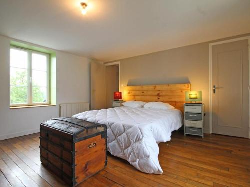 a bedroom with a large bed with a wooden headboard at Maison Normande avec Jardin Clôturé, Cheminée et Options Confort, près de la Roche d'Oëtre - FR-1-497-141 in Frênes