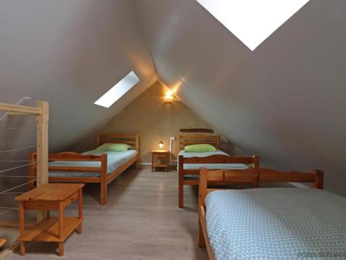 Zimmer im Dachgeschoss mit 3 Etagenbetten und einem Tisch in der Unterkunft Maison rénovée avec jardin et animaux acceptés près du Haras du Pin - FR-1-497-236 in Gouffern en Auge
