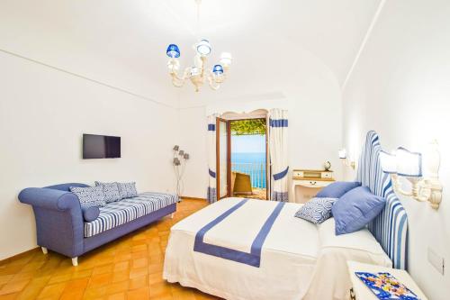波西塔諾的住宿－五家公寓酒店，一间卧室配有一张床和一张沙发