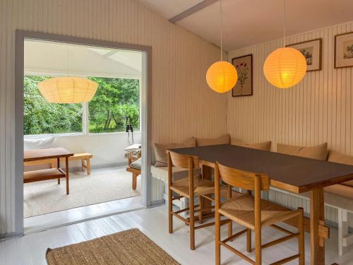a dining room with a table and chairs and lights at Nature-Rich 60S Holiday Home By Isefjord in Jægerspris