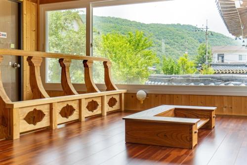 a room with a wooden staircase with a large window at Yongin Yejik Hanok Pension in Yongin