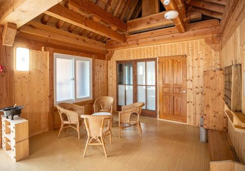 a dining room with a table and chairs in a cabin at Yongin Yejik Hanok Pension in Yongin