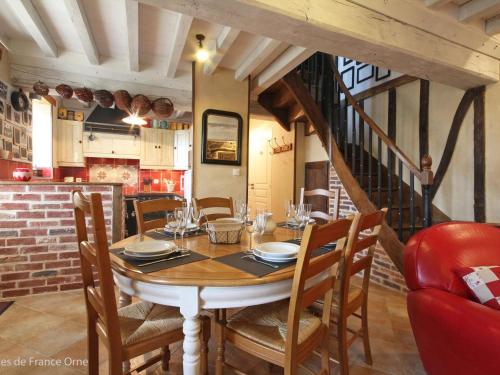 une salle à manger avec une table, des chaises et un escalier dans l'établissement Maison 6 pers avec sauna et jardin, Suisse Normande - FR-1-497-172, à Bréel