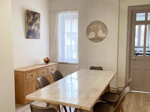 une salle à manger avec une table et des chaises en bois dans l'établissement Triplex rénové 4 chambres au cœur de Blois avec wifi - FR-1-491-455, à Blois