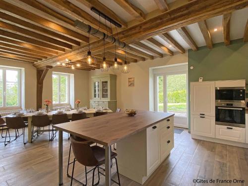 une cuisine avec une table et une salle à manger dans l'établissement Gîte familial de charme pour 13 pers. avec cheminée historique, terrasse, jardin et 3 salles d'eau. - FR-1-497-209, à La Ménière