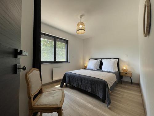 une chambre avec un lit, une fenêtre et une chaise dans l'établissement Gîte cosy en forêt avec terrasse, proche étang et loisirs, 3 chambres, wifi, plancha et parking - FR-1-489-453, à Cérilly