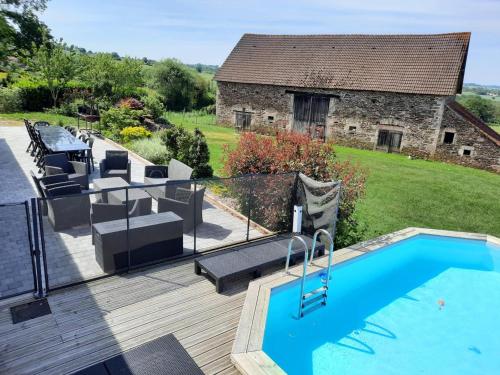 une piscine sur une terrasse à côté d'une maison dans l'établissement Longère rénovée avec piscine privée, Wi-Fi et climatisation - FR-1-489-201, à Échassières