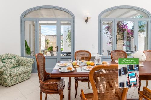 Un comedor con mesa y sillas en Masseria Lamagrotte By Raro Rooms, en Rosa Marina