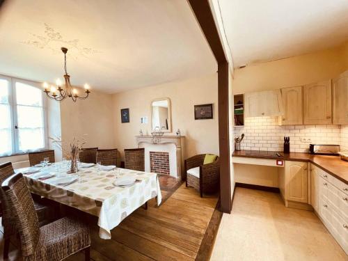 une salle à manger avec une table et une cuisine dans l'établissement Éco-presbytère rénové avec jardin, idéal pour 7 personnes - La Gonfrière, Normandie - FR-1-497-78, à La Gonfrière