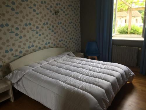 un letto in una camera da letto con un muro e una finestra di Gîte rustique avec cheminée, jardin, vélos à dispo, proche châteaux de la Loire et ZooParc de Beauval - FR-1-491-442 a Nourray