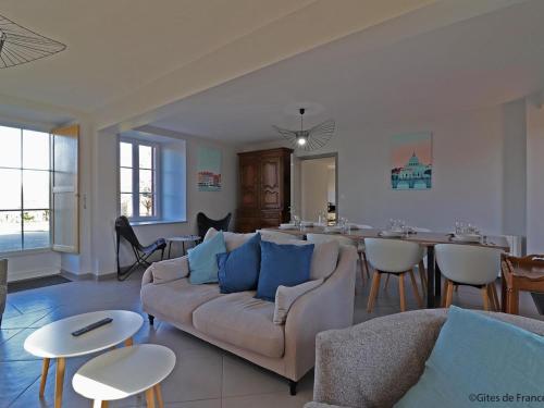 a living room with a couch and a dining room at Maison normande rénovée avec grand jardin, idéale pour famille, proche lac et randonnées - FR-1-497-143 in Ménil-Gondouin