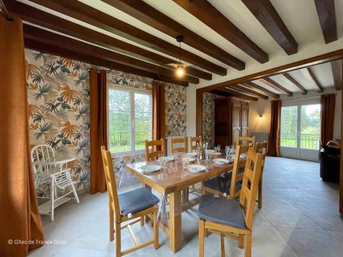 une salle à manger avec une table et des chaises en bois dans l'établissement Maison spacieuse au cœur du Perche, jardin clos, WIFI, animaux admis - FR-1-497-232, à Moutiers-au-Perche