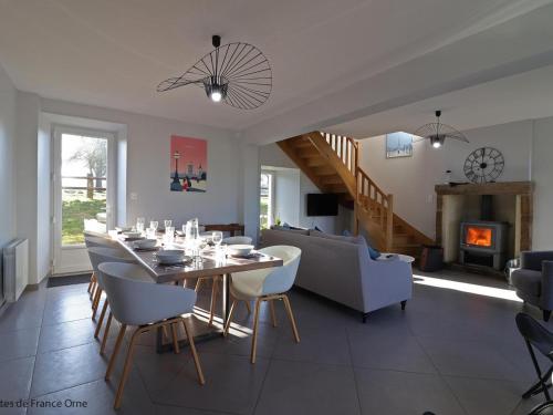 a dining room and living room with a table and chairs at Maison normande rénovée avec grand jardin, idéale pour famille, proche lac et randonnées - FR-1-497-143 in Ménil-Gondouin