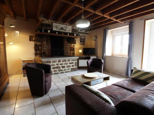 a living room with a couch and a fireplace at Maison de charme avec jardin, nature, cheminée, WiFi, proche manoirs et rivières tortueuses - FR-1-497-99 in Saint-Bômer-les-Forges