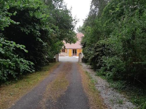 a dirt road with a house in the distance at Maison de charme avec jardin, nature, cheminée, WiFi, proche manoirs et rivières tortueuses - FR-1-497-99 in Saint-Bômer-les-Forges