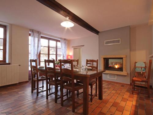 une salle à manger avec une table et des chaises et une cheminée dans l'établissement Maison Percheronne Spacieuse avec Billard, Babyfoot, et Jardin Clos, Animaux Bienvenus ! - FR-1-497-65, à La Ménière
