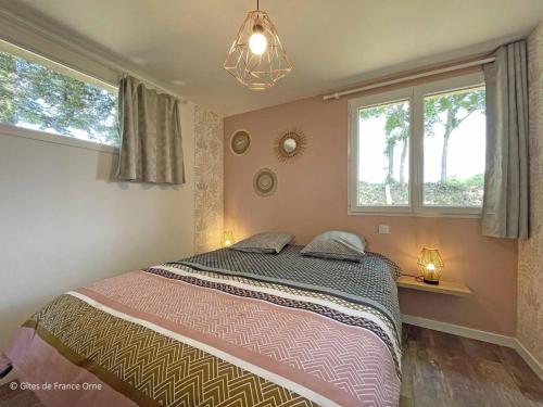 a bedroom with a bed and two windows at Maison en Pierre avec Jardin, Séances Bien-Être et Activités Nature - Pays du Poiré, Normandie - FR-1-497-208 in Mantilly