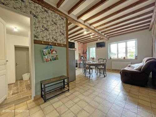 a living room with a couch and a table at Maison en Pierre avec Jardin, Séances Bien-Être et Activités Nature - Pays du Poiré, Normandie - FR-1-497-208 in Mantilly