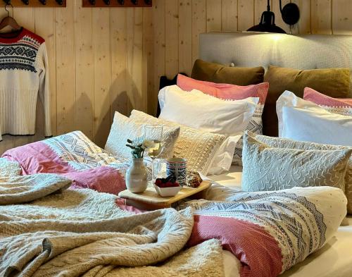 a pile of pillows sitting on top of a bed at Family-Friendly Mountain Cabin At Haglebu in Eggedal