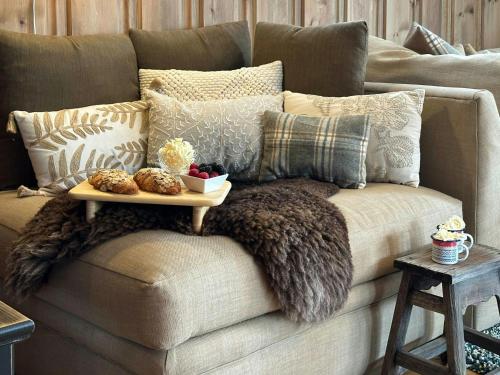 a couch with pillows and a tray of food on it at Family-Friendly Mountain Cabin At Haglebu in Eggedal