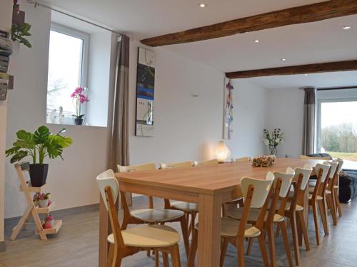 une salle à manger avec une table et des chaises en bois dans l'établissement Maison authentique rénovée 7ha, étang, confort moderne, idéal pour familles, animaux acceptés - FR-1-497-53, à Le Cercueil