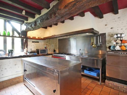 a large kitchen with a large stainless steel counter at Charmant Gîte de Chasse avec Grand Jardin, WIFI, Cheminée, et Confort Moderne - Animaux Acceptés - FR-1-497-166 in Le Chêne dʼAuvilliers