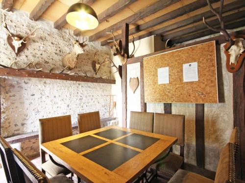 a dining room with a table and some deer heads on the wall at Charmant Gîte de Chasse avec Grand Jardin, WIFI, Cheminée, et Confort Moderne - Animaux Acceptés - FR-1-497-166 in Le Chêne dʼAuvilliers